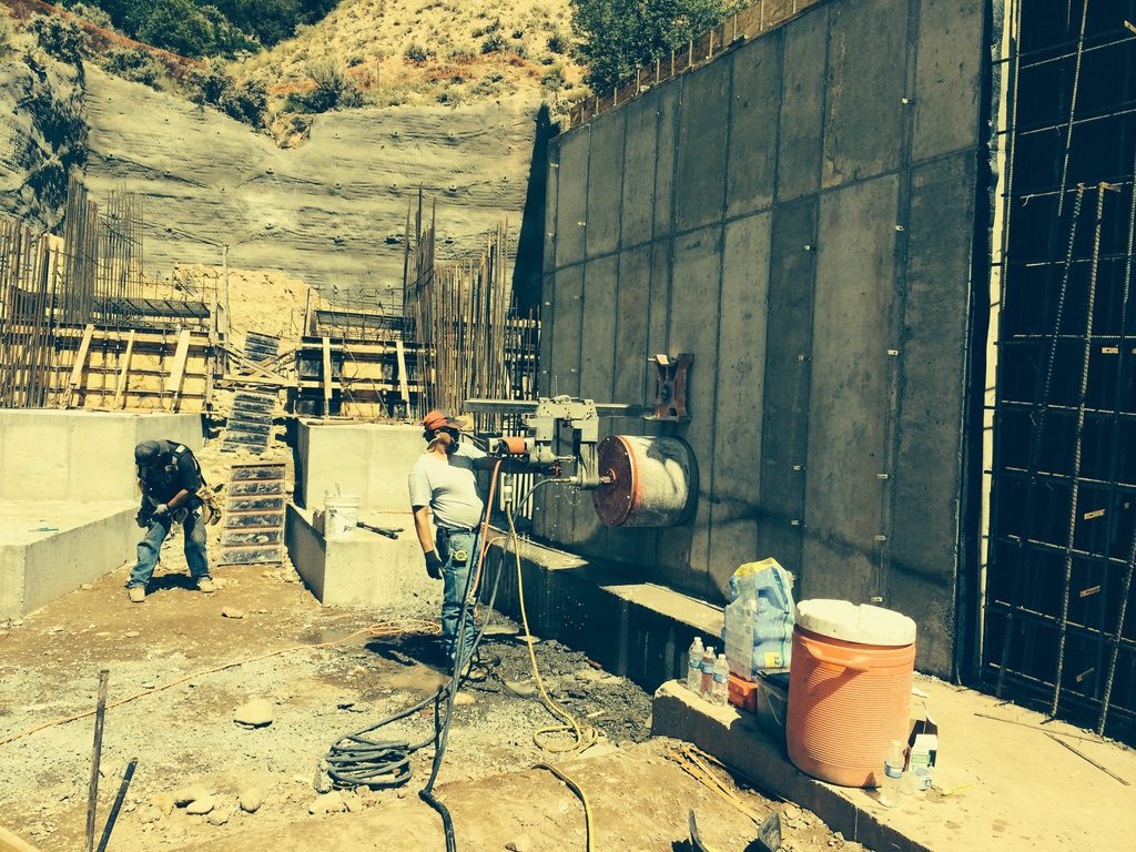 Crew saw-cutting a concrete wall on site